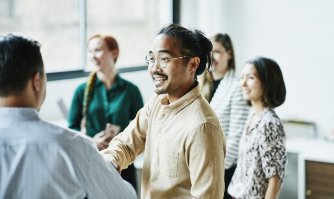 Businessman Shaking Hands With Colleague After Meeting In Office